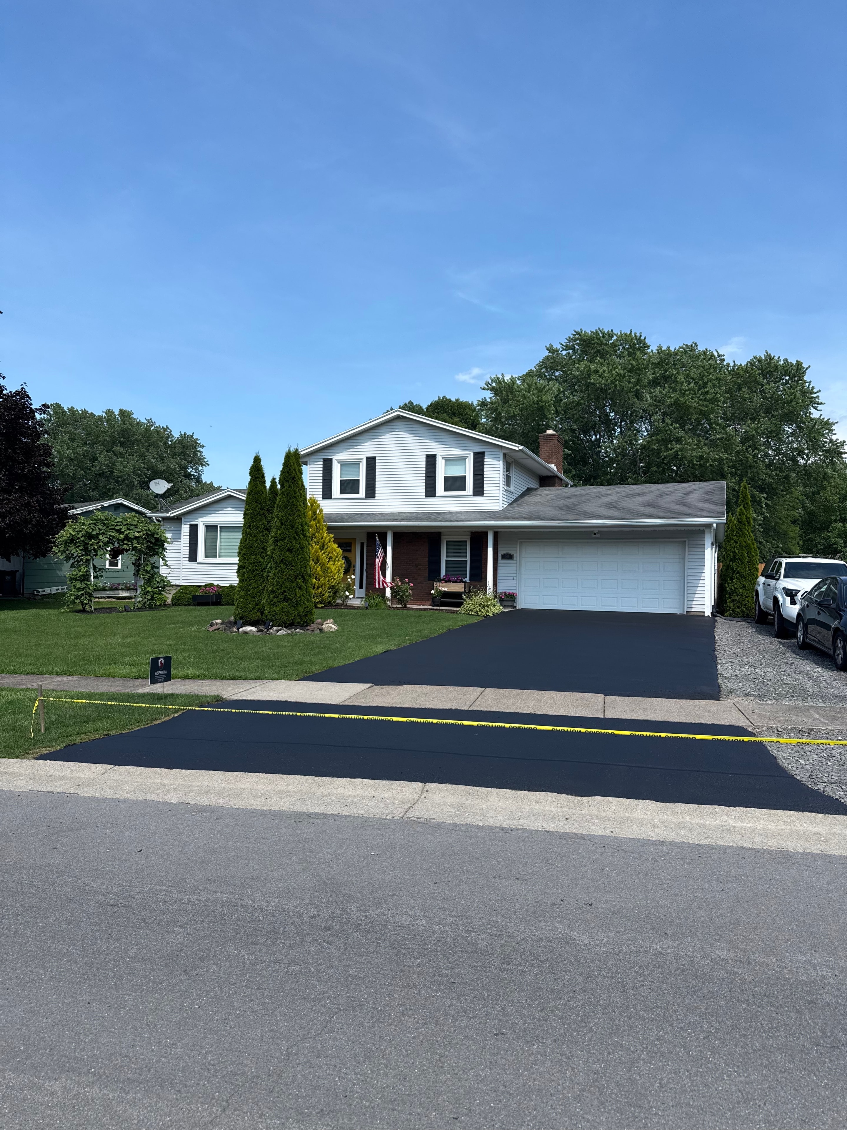 Asphera crew applying sealcoat to a residential driveway in Monroe County NY