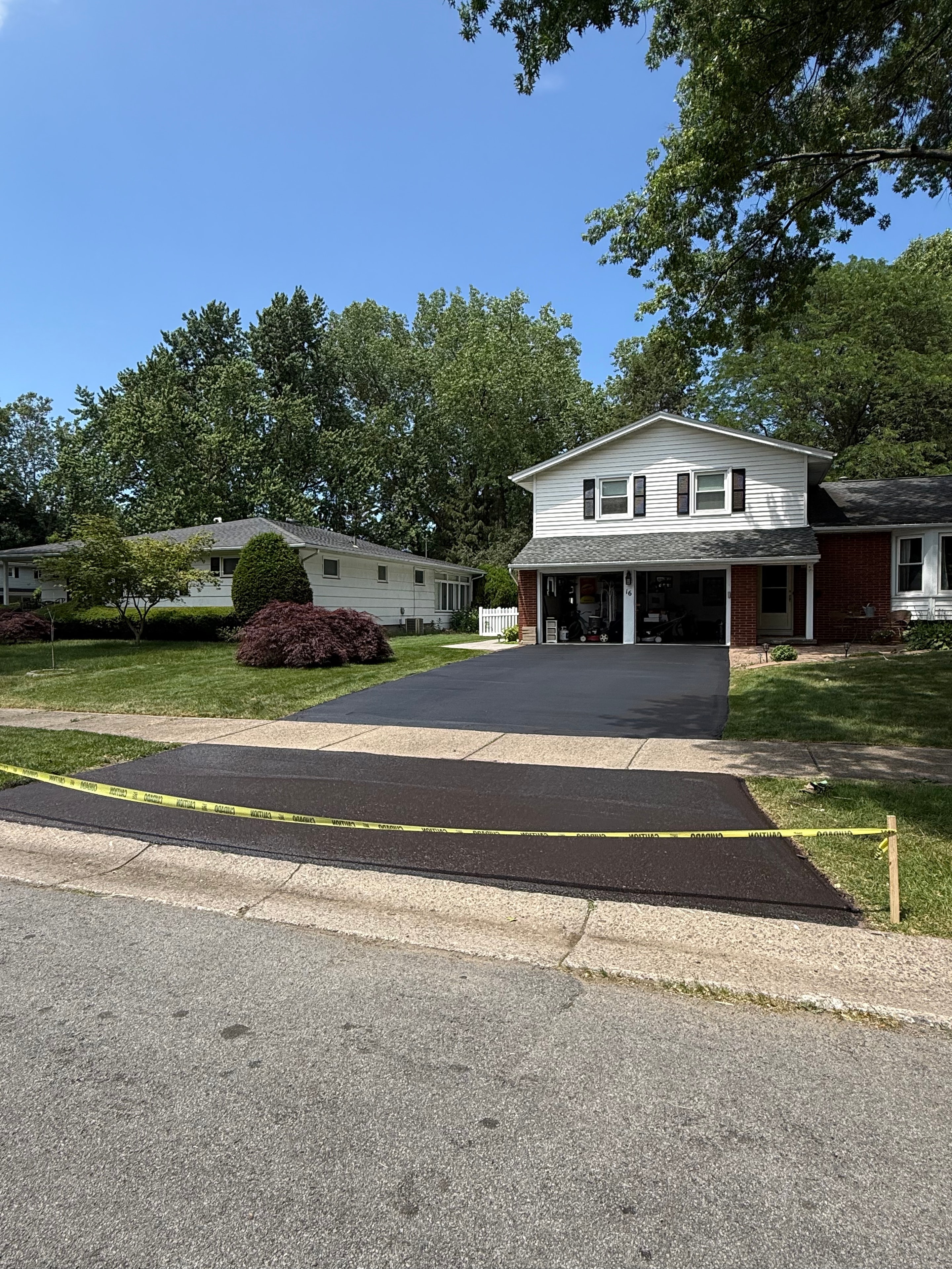 Asphera sealcoating team finishing a driveway job in Rochester NY