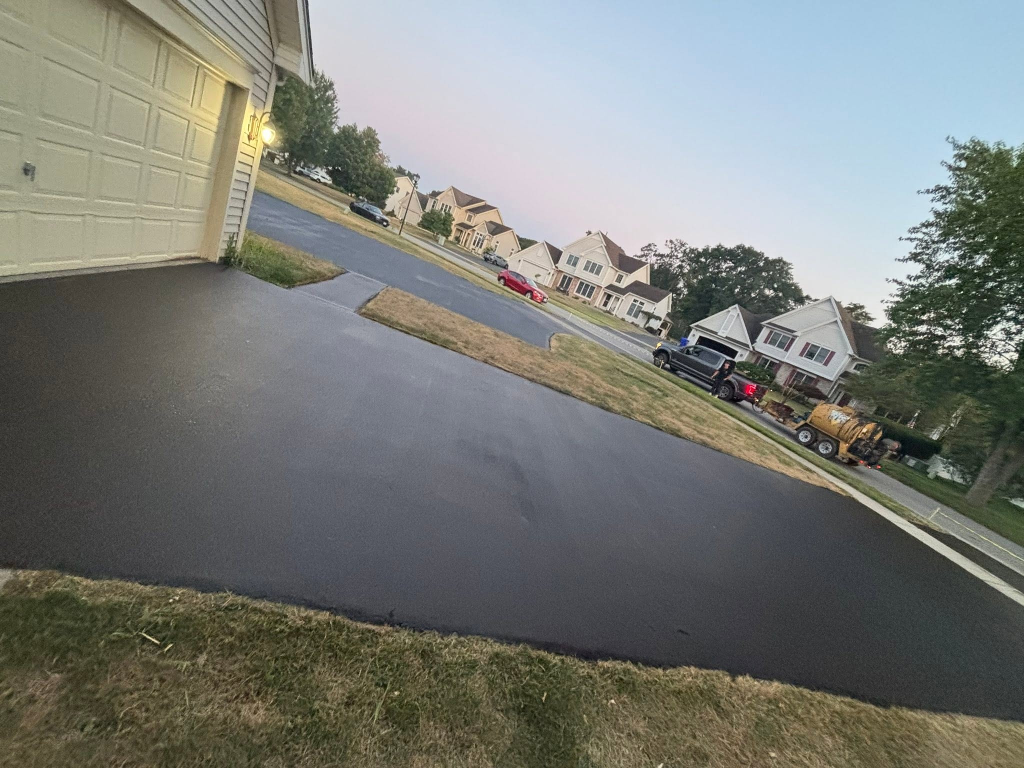 Freshly sealed jet-black residential driveway completed by Asphera Sealcoating in Monroe County NY