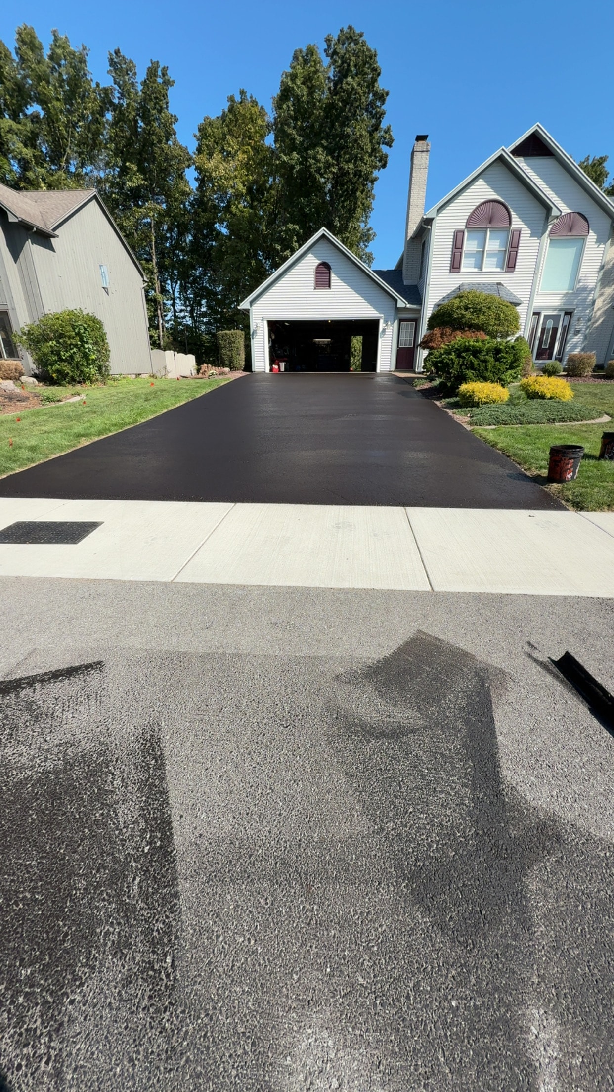 Completed sealcoating job on a wide residential driveway in Monroe County NY by Asphera
